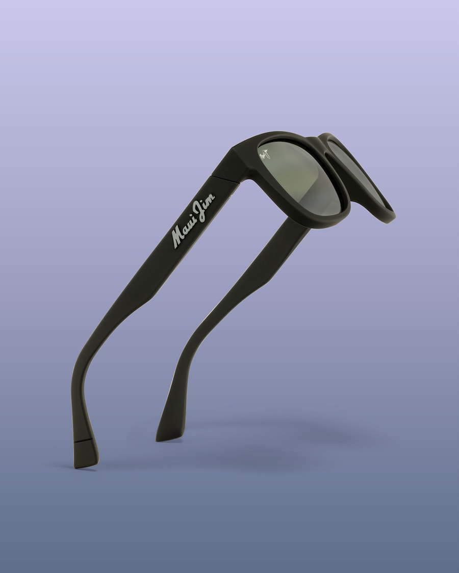 Black Maui Jim sunglasses with logo on temple against a cool gradient background